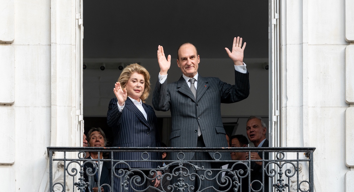 Man and woman waving from balcony