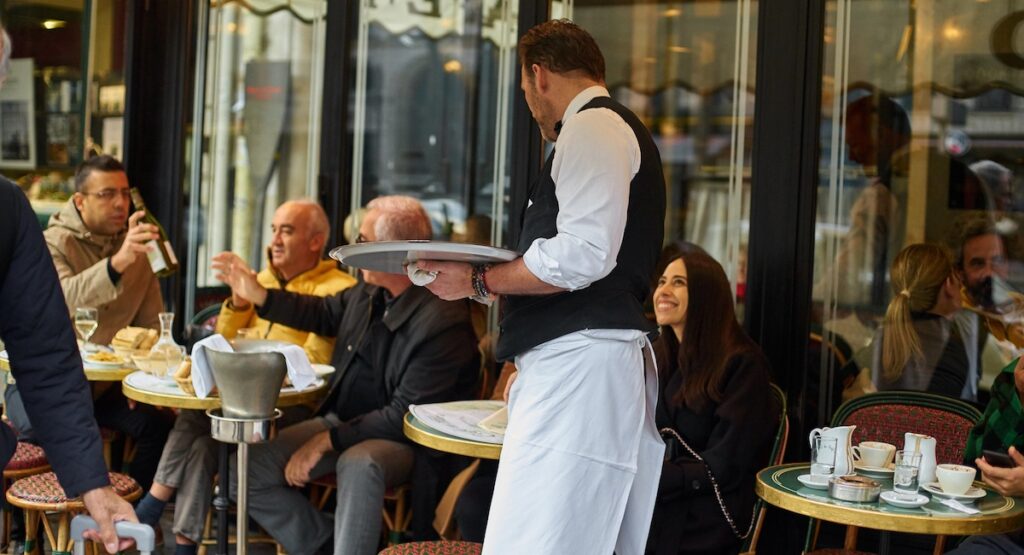 Waiter serving coffee at Paris cafe