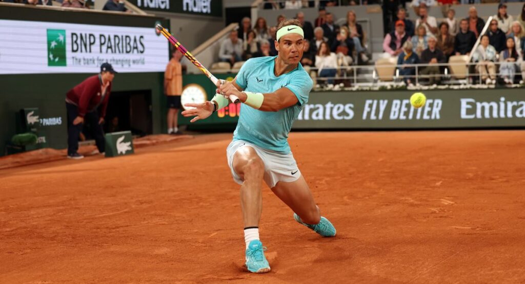 Tennis player hitting the ball at Roland Garros.