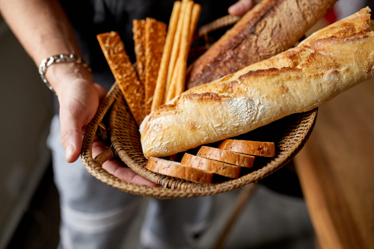 Person holding basket of baguette