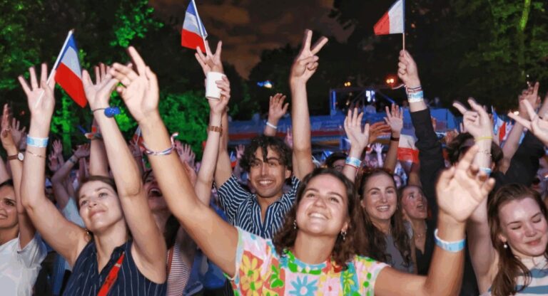 People celebrating with French flags at a concert