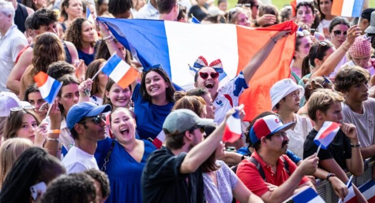 People waving French flag in large crowd
