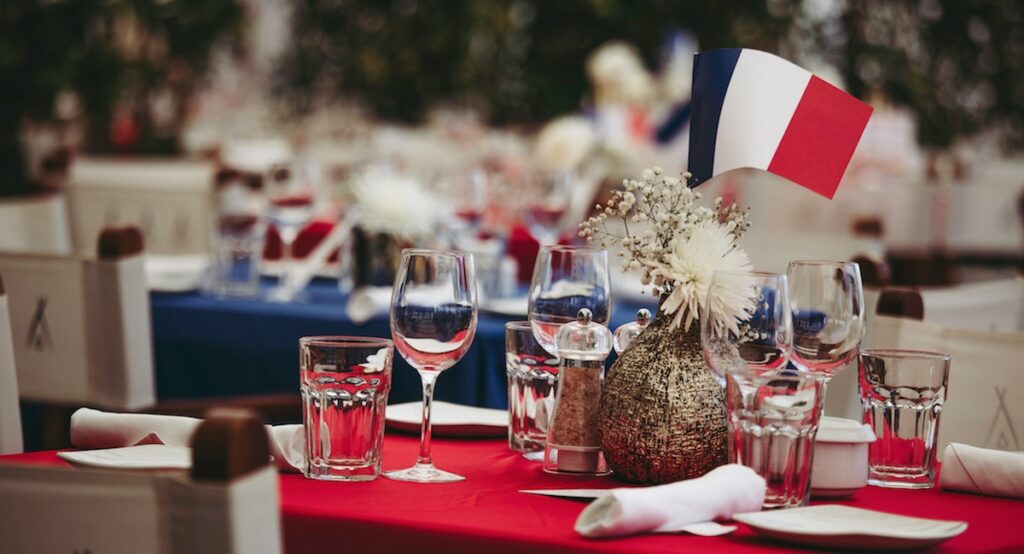 Table set with wine glasses and small French flag