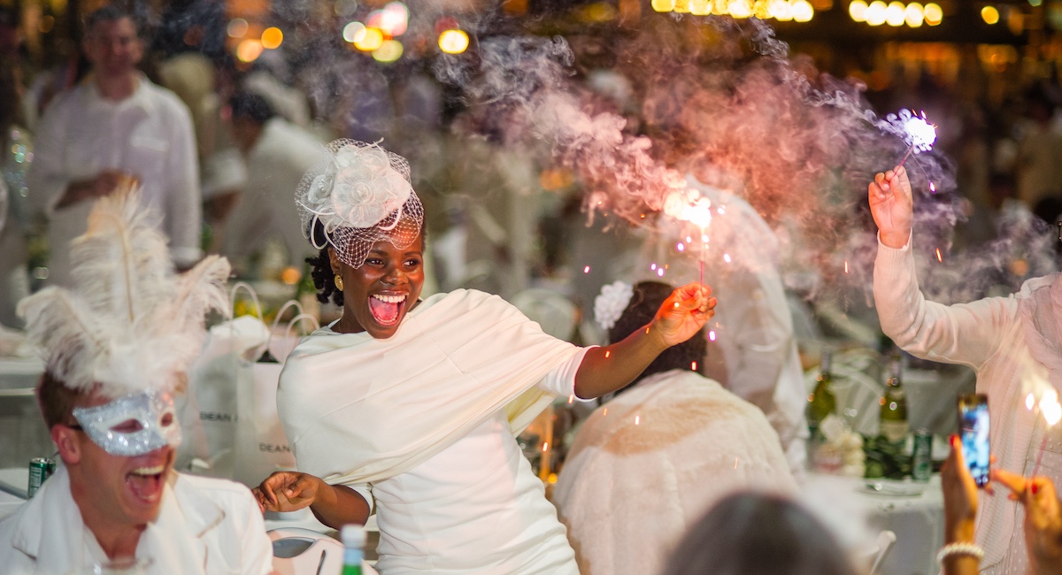 People dressed in white partying and setting off sparklers