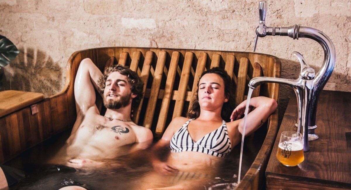 Couple lounging in hot tub full of beer