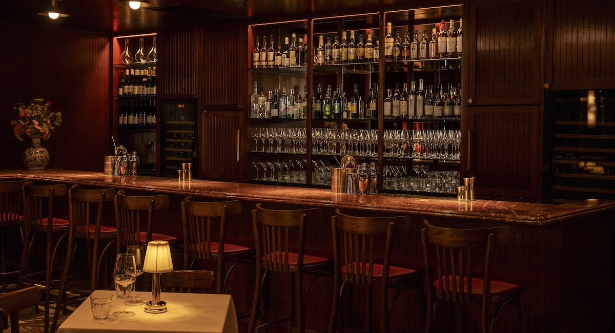 Bar at Chateau Royale, with dark wood paneling and red marble bar