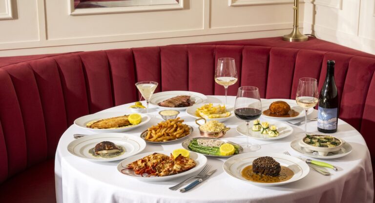 Various French dishes laid out on table in front of red booth