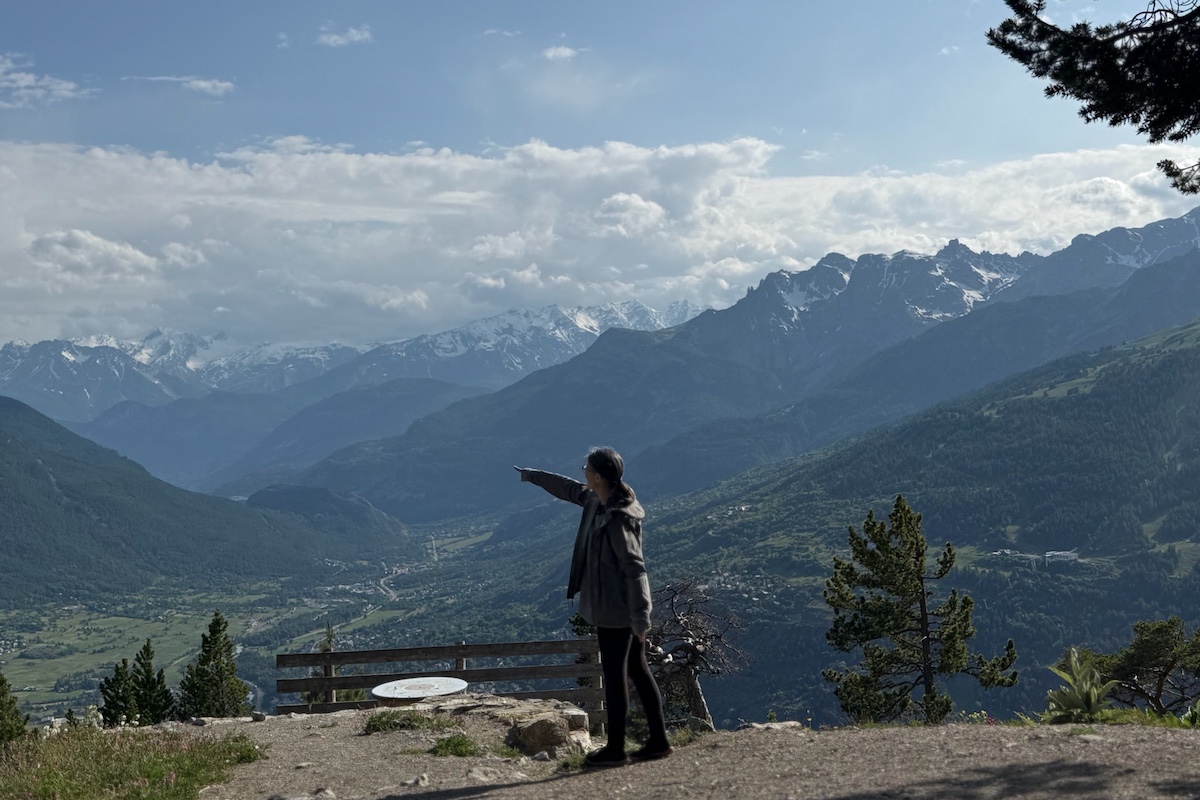 Woman pointing at top of hiking outlook in the Alps