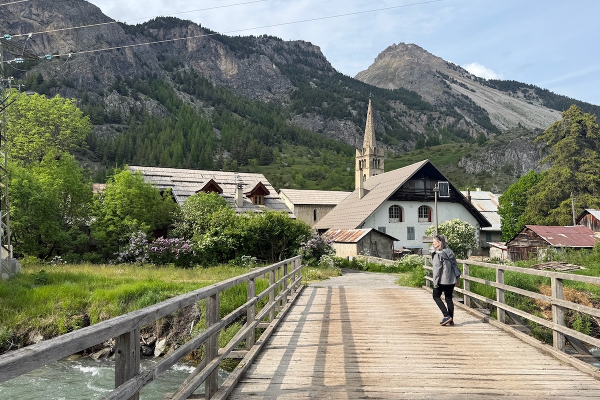 Wooden bridge leading to small hamlet of Nevache in the French Alps.