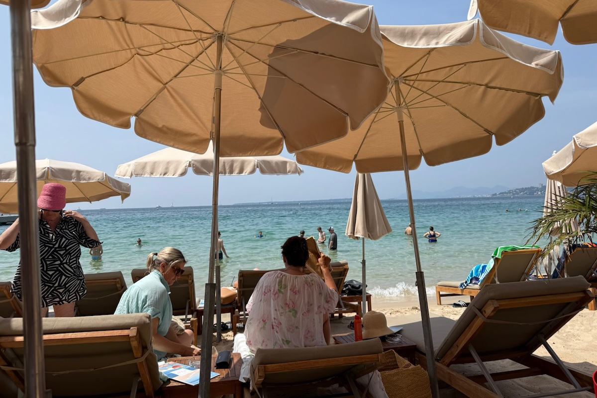 People in sun loungers under beach umbrellas in Antibes