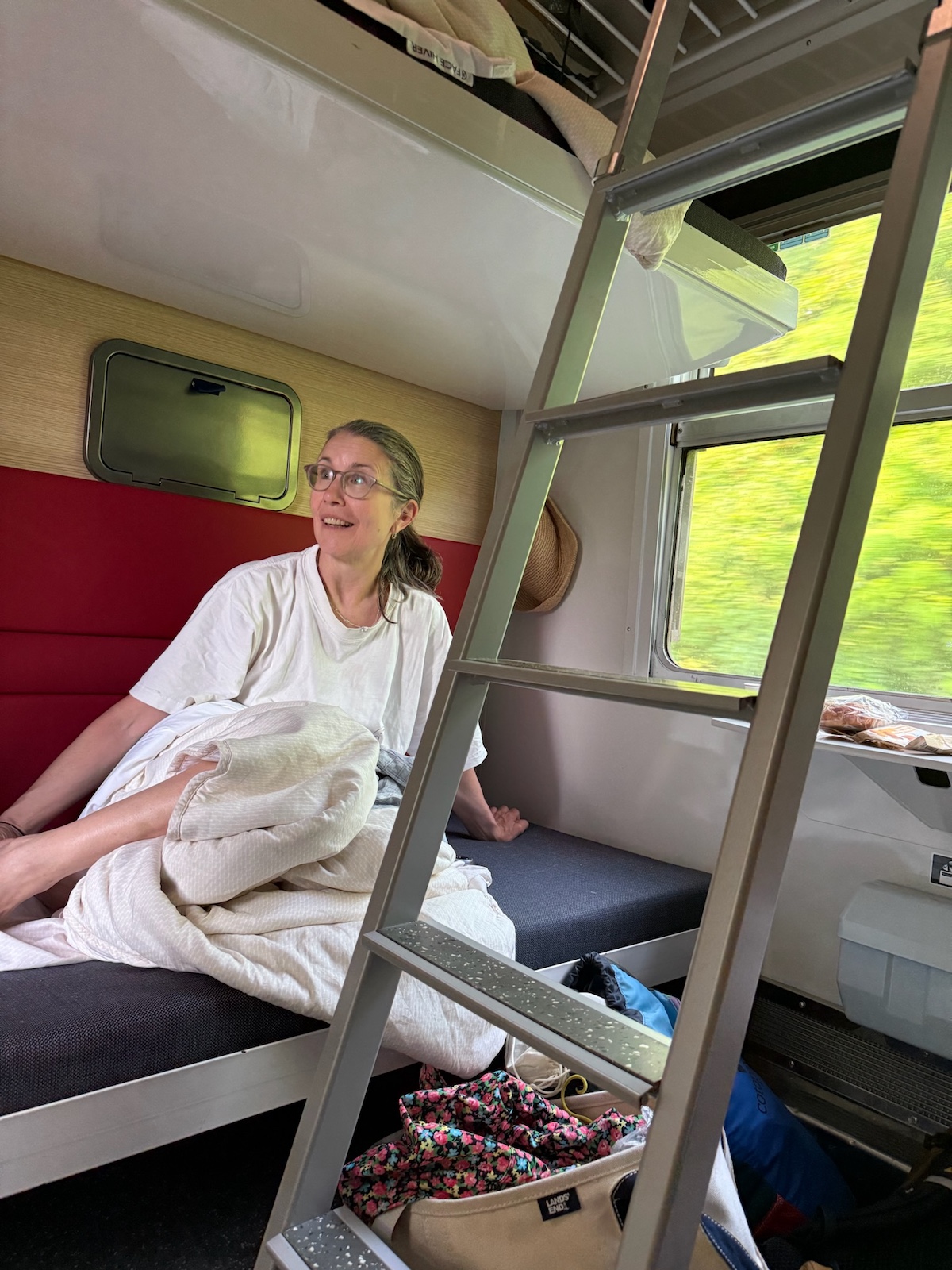 Woman in bottom bunk of sleeper train compartment