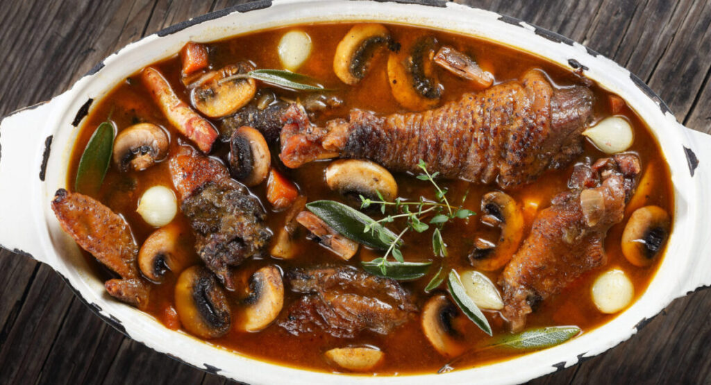 A coq au vin simmered in a saucepan. 