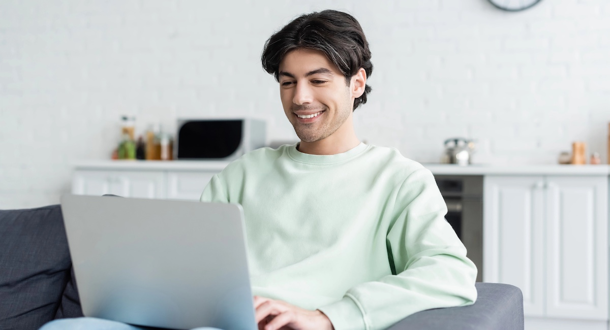 Smiling man working on laptop