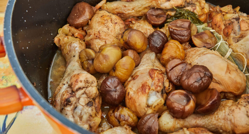 Pieces of chicken mixed with chestnuts in a casserole dish. 