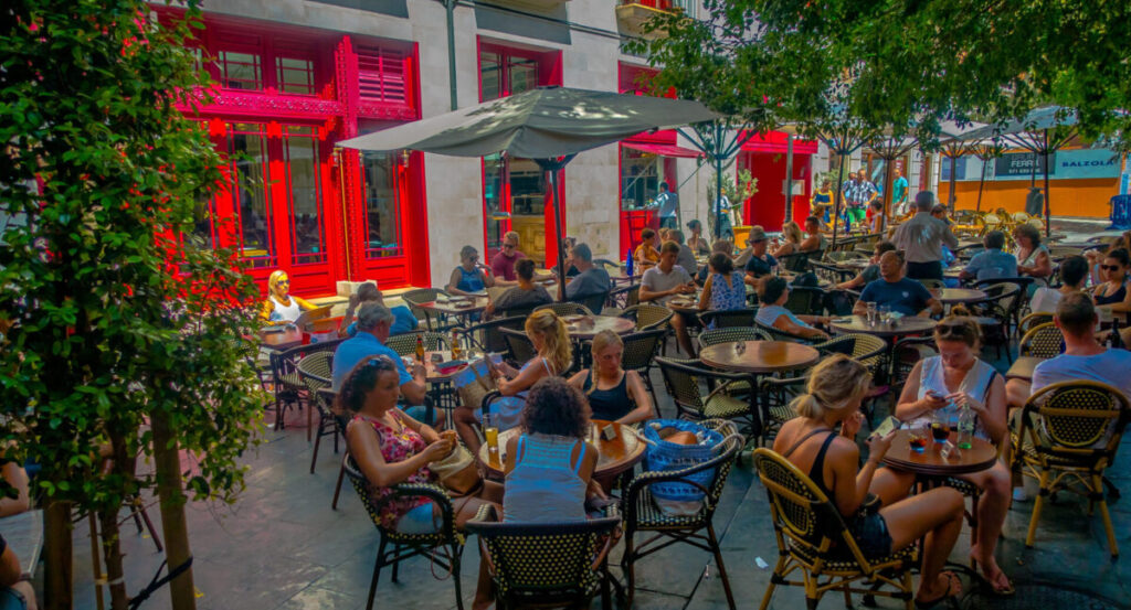A crowded bar terrace at sunset.