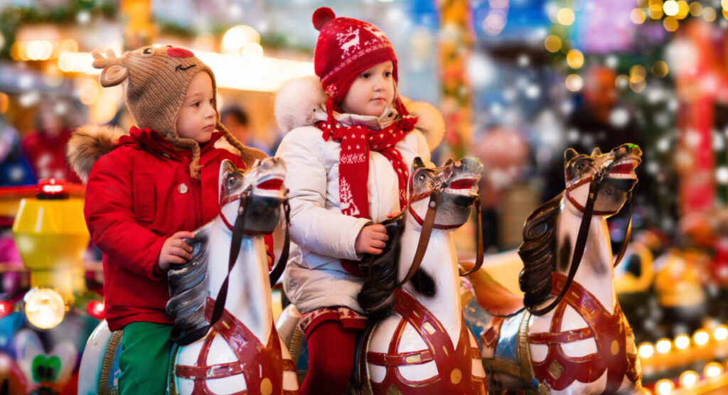 Children riding carousel on Christmas market.