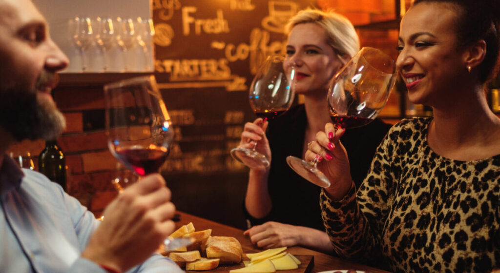 A group of friends are drinking wine in a bar.