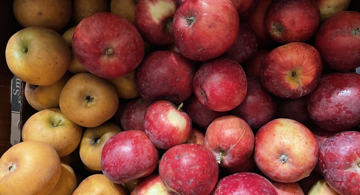 Box full of apples of various colors