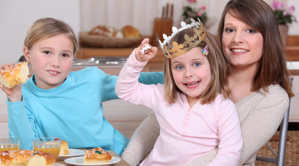 
Two little girls share a king cake with their mom.