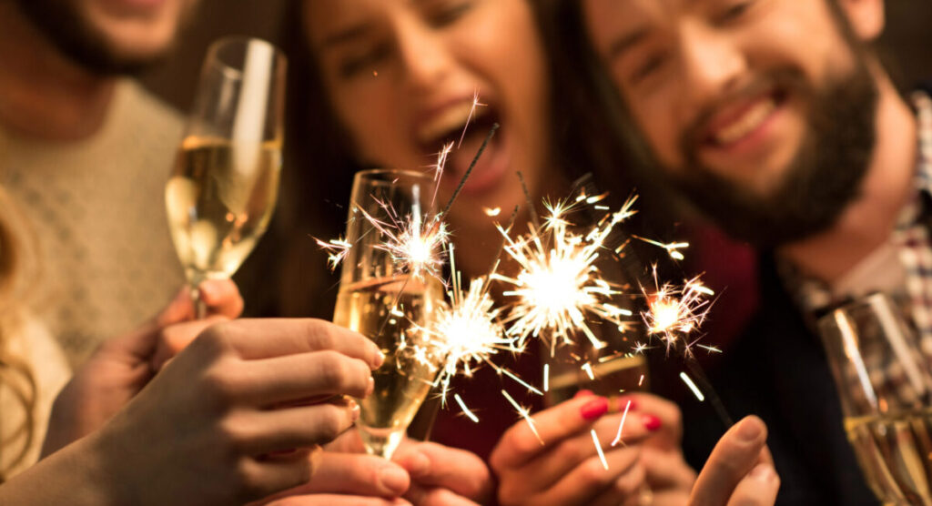 People with glasses of champagne and sparklers.