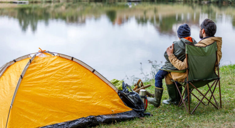 Father and son sitting at tent.
