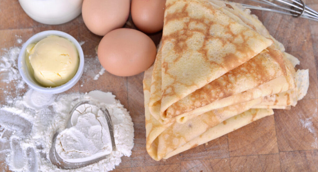 Homemade french pancakes with ingredient and heart shaped in the flour.
