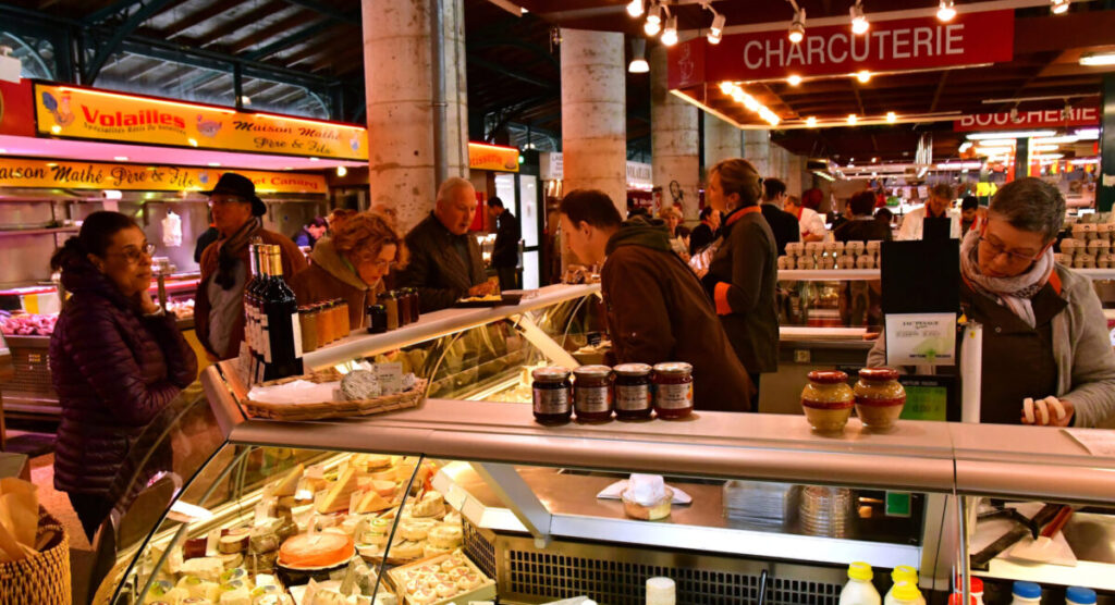 Market halls with cheese, charcuterie, and meat stalls.