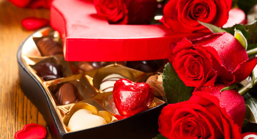 Box of chocolate truffles with red roses.