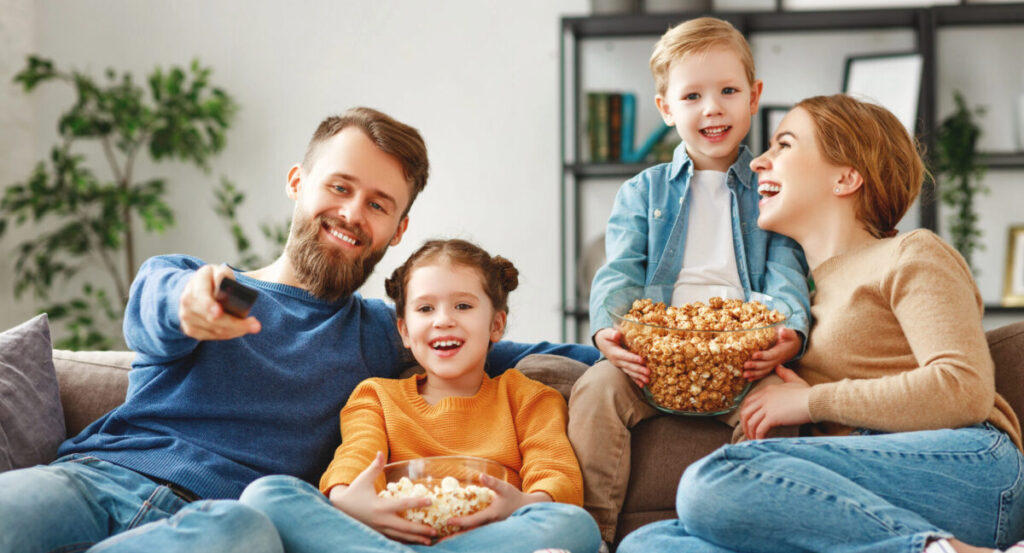 Happy parents with kids sitting on couch.