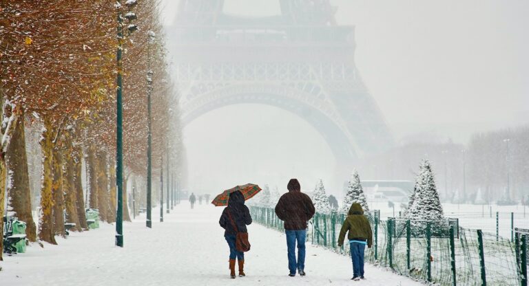 People walking by Eiffel Tower on a snowy day in Paris