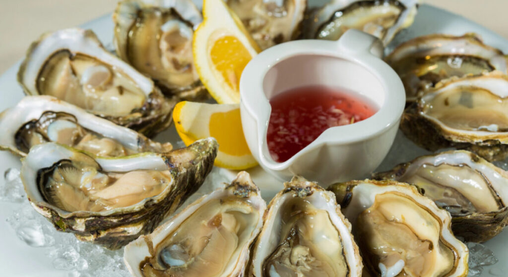 A platter of fresh organic raw oysters on ice.