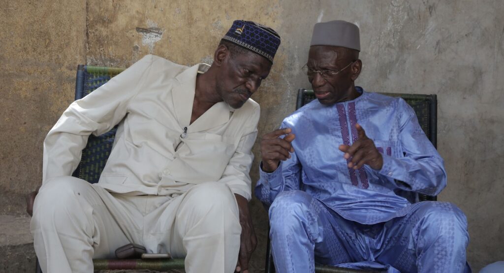 Two men in African dress having a conversation.
