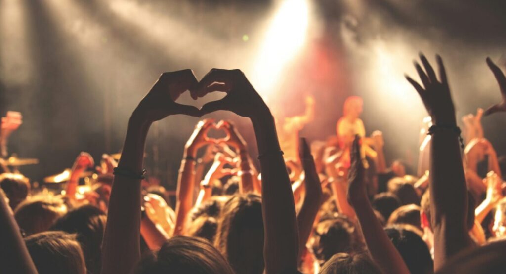 A crowd of fans in front of a concert stage.