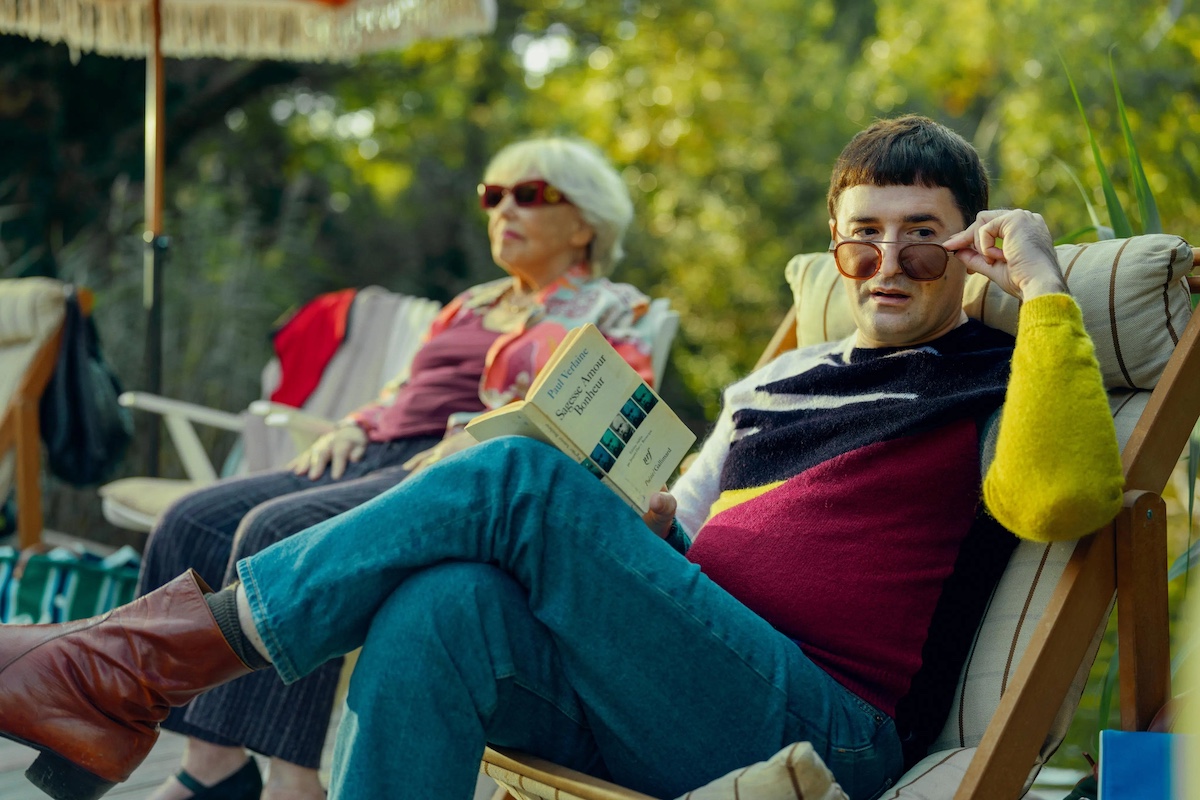 Old woman and young man reclining on beach chairs.