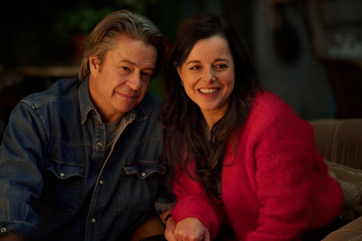 Man and woman holding hands and smiling.