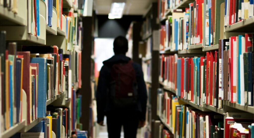 A student is walking in a library.