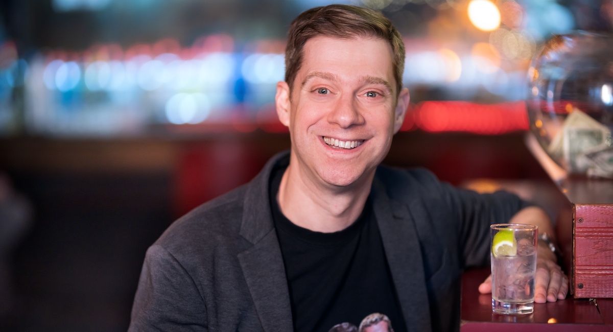 Photo of smiling man sitting at bar.