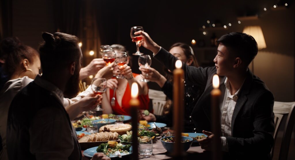 Group of friends toasting at a candlelit dinner party.