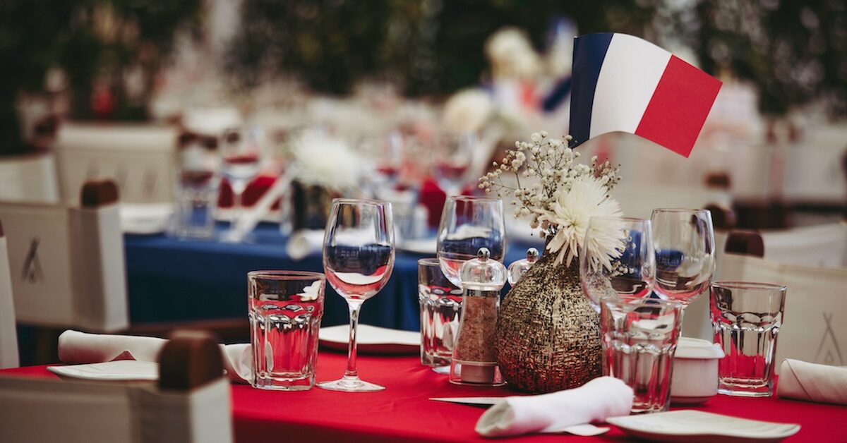 Table set with wine glasses and small French flag