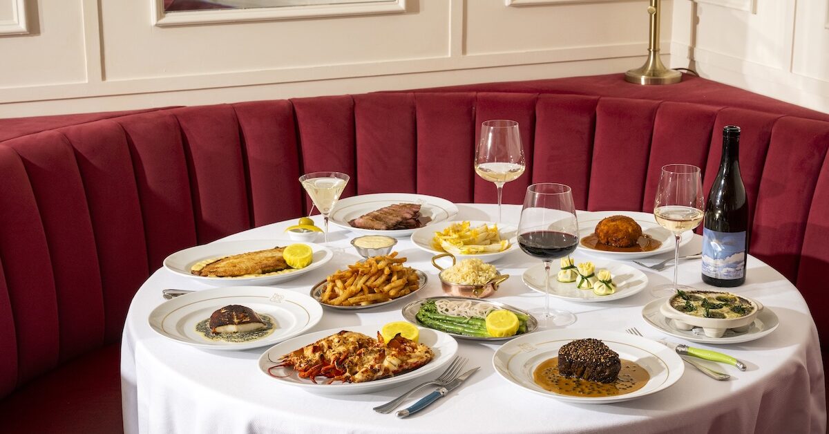 Various French dishes laid out on table in front of red booth