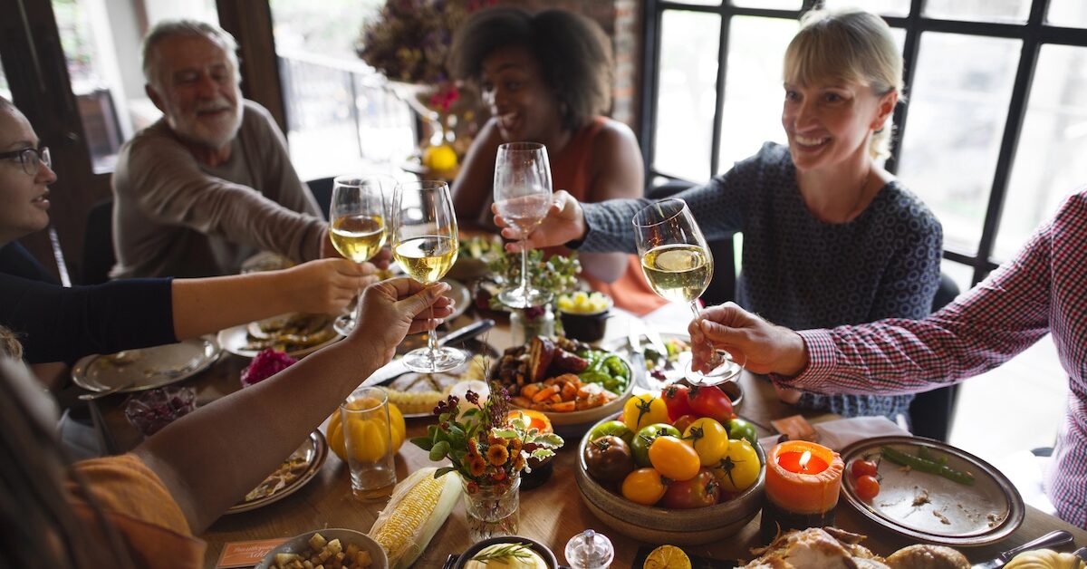 People share a toast over a Thanksgiving dinner