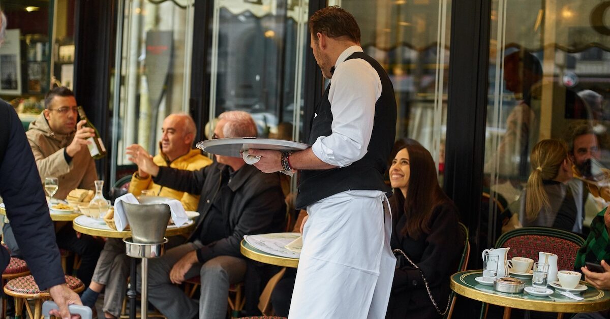 Waiter serving coffee at Paris cafe