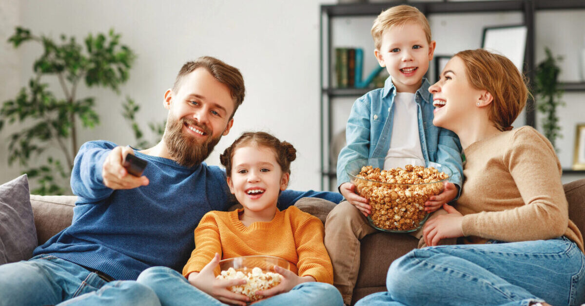 Happy parents with kids sitting on couch.