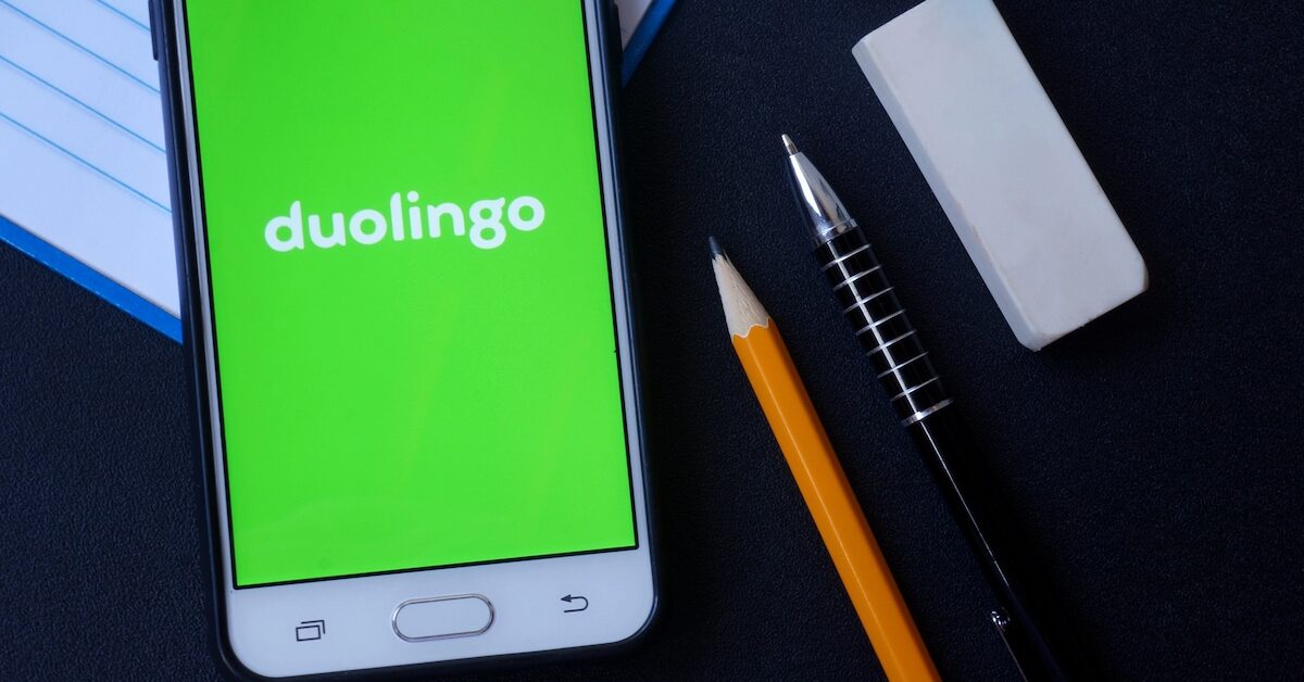 Phone with Duolingo app running beside pen and pencil