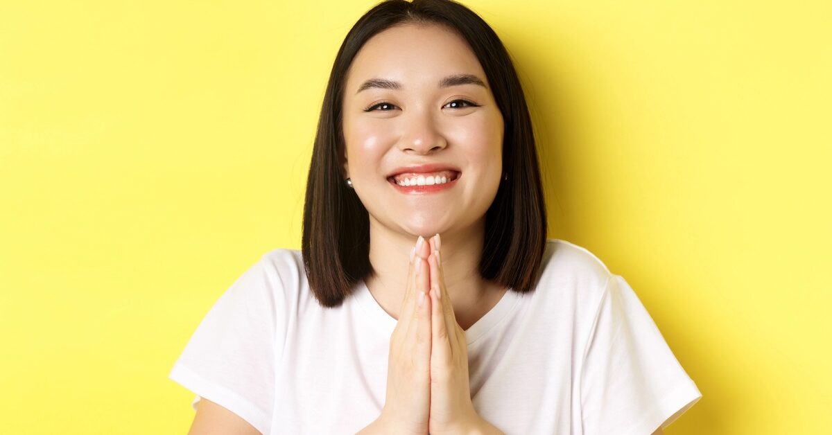 Smiling woman with her hands together in thanks