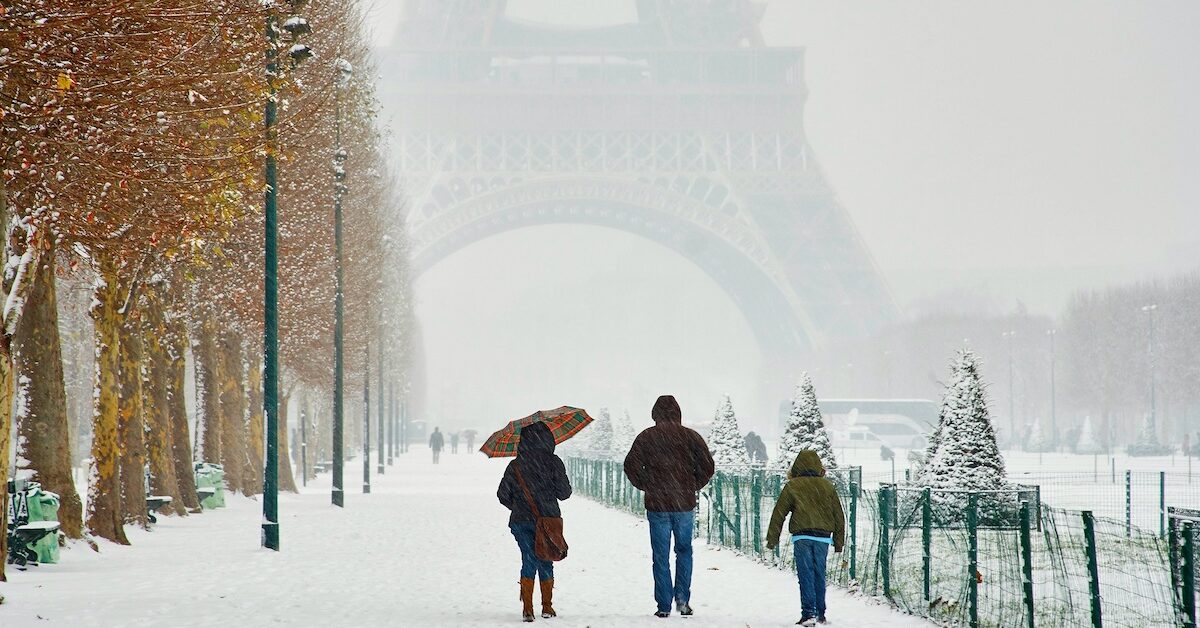 People walking by Eiffel Tower on a snowy day in Paris