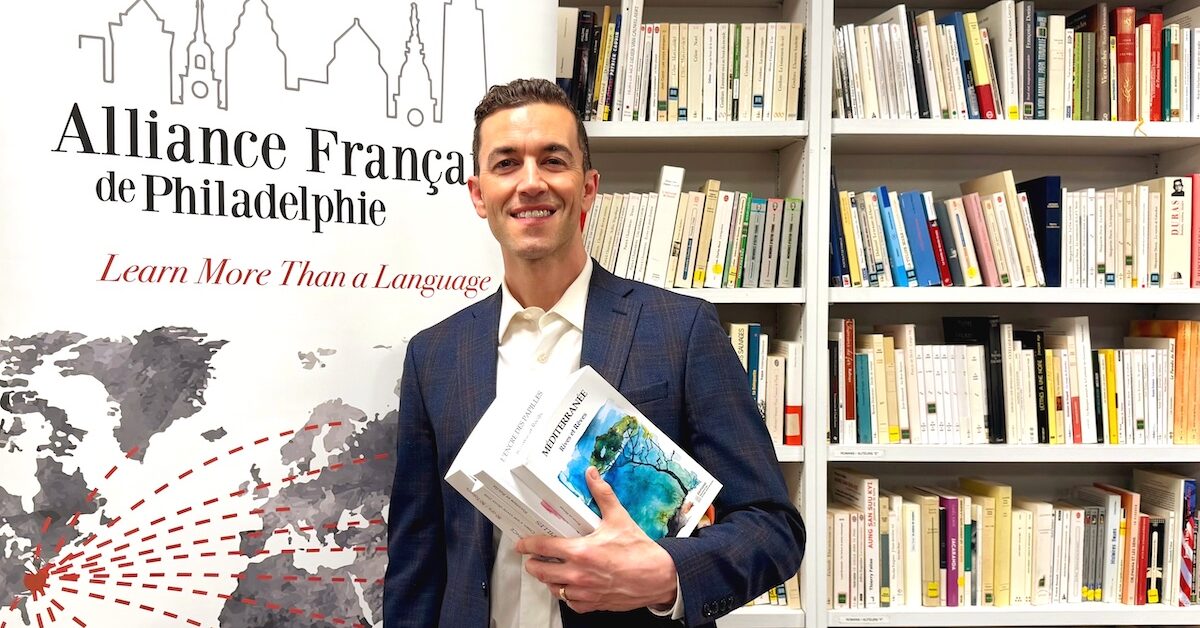 AF Philadelphie Director, Philippe Poirier, standing in front of bookcase.
