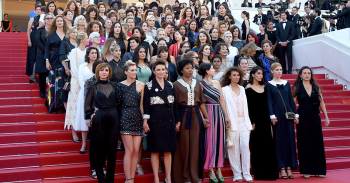 A group of people standing in front of a crowd posing for the camera