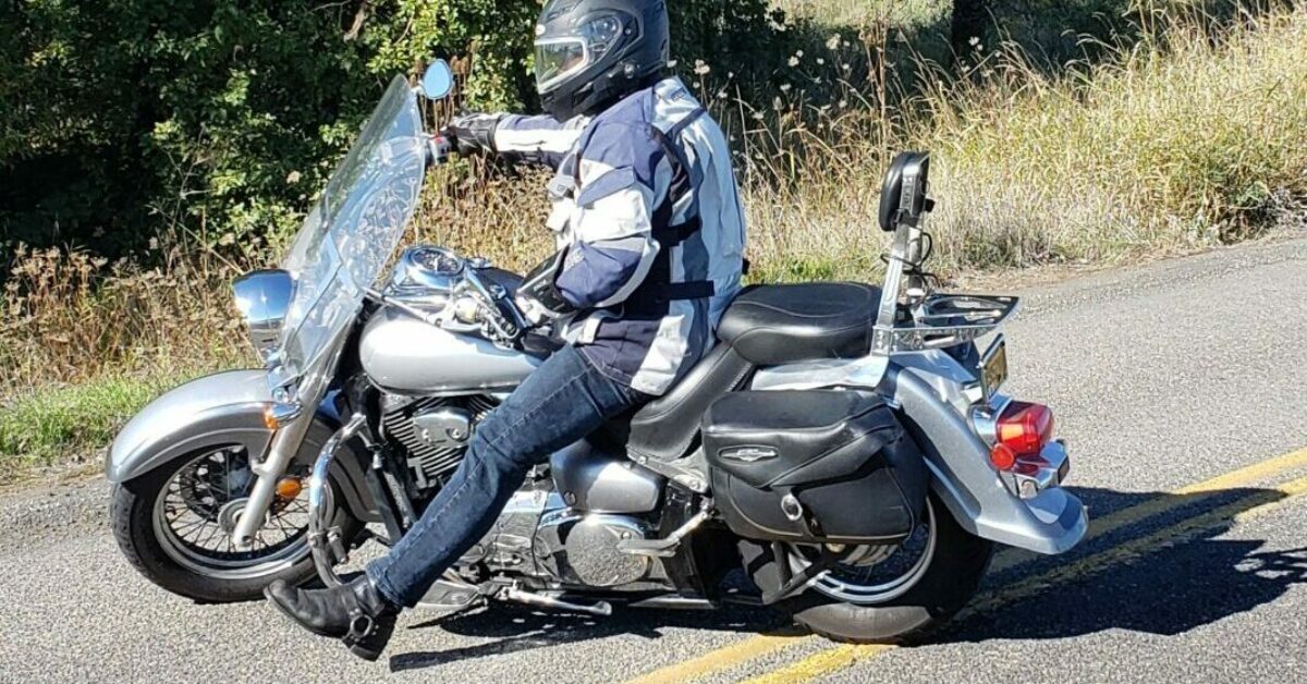 A person wearing a helmet and sitting on a motorcycle