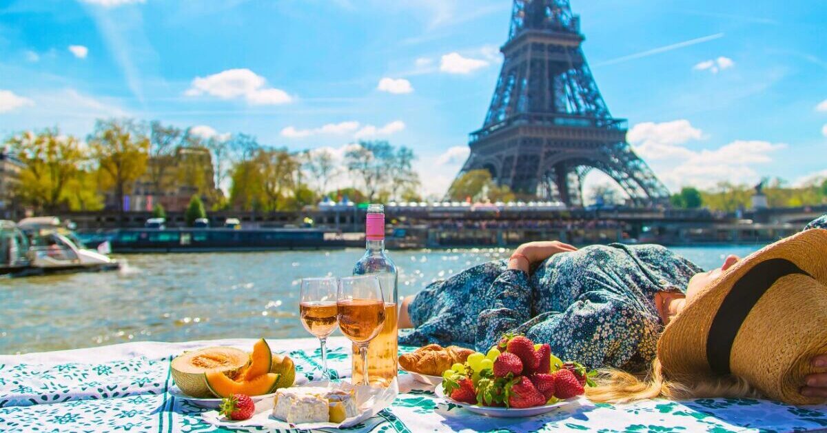 Woman with picnic in front of Eiffel Tower.